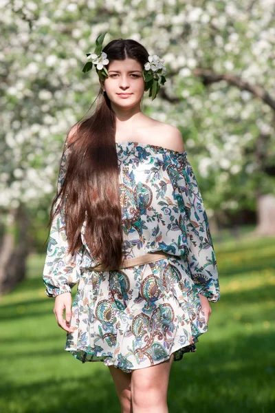 La ragazza dai capelli lunghi contro meli fiorenti . — Foto Stock