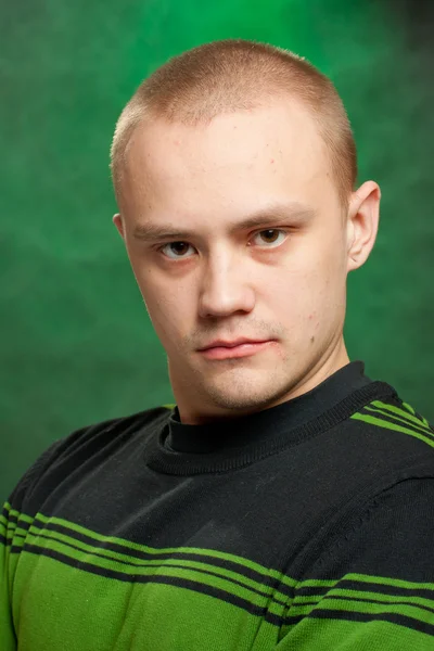 Yeşil bir arka planda yeşil giysili genç portresi — Stok fotoğraf