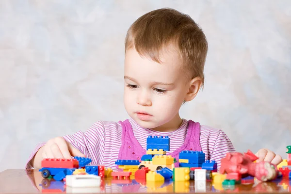 Dziecko w rózowej sukni z zabawkami — Zdjęcie stockowe