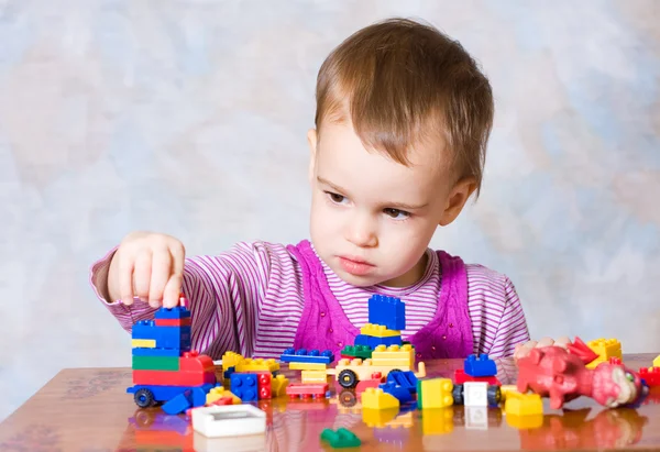 The child in a pink dress with toys — Stock Photo, Image