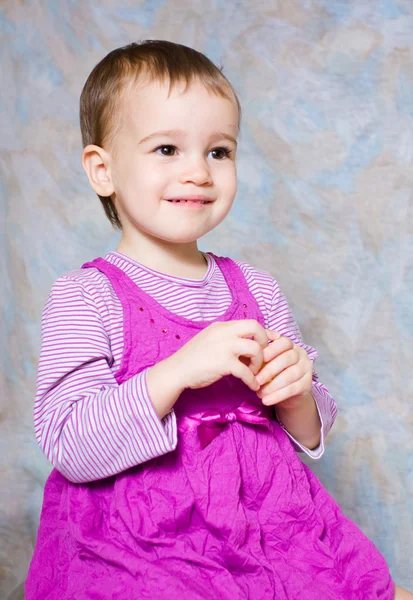 El niño en un vestido rosa con juguetes —  Fotos de Stock