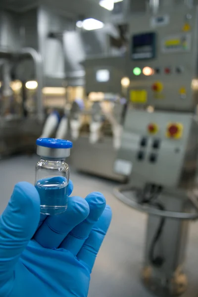 Guanto di gomma con in mano una bottiglia di medicinale — Foto Stock