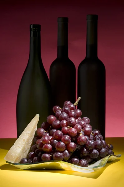 Red grape and wine bottle still life — Stock Photo, Image