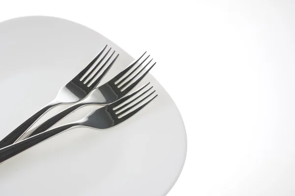 Forchette su un piatto sopra bianco — Foto Stock