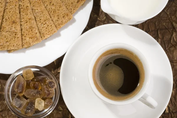 크래커, 갈색 설탕 및 우유를 가진 블랙 커피 컵. — 스톡 사진