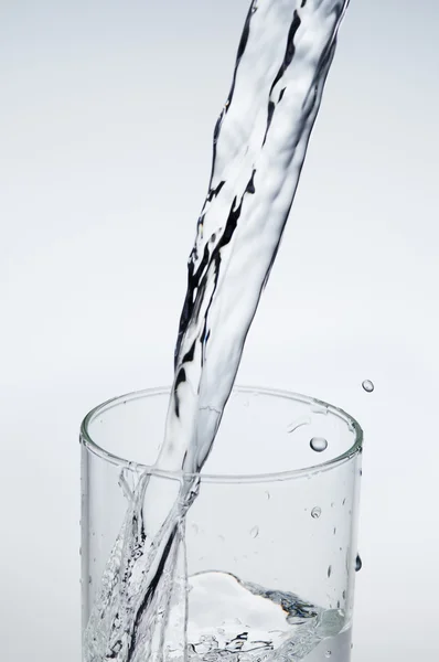 Mineralwasserstrahl in ein Glas gießen — Stockfoto