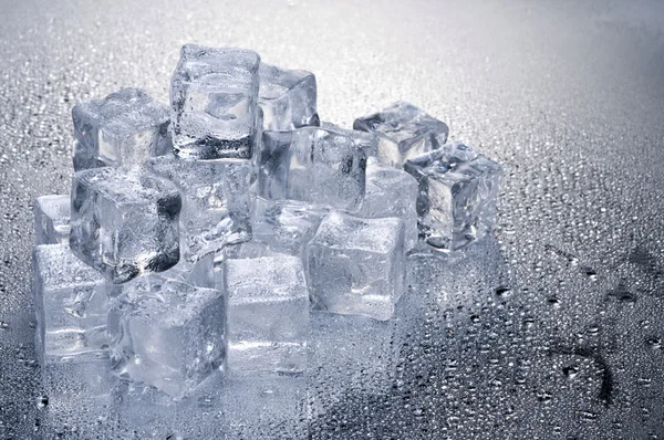 Cubos de gelo sobre fundo molhado — Fotografia de Stock