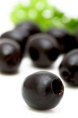 Black olives on a plate closeup, focus on foreground