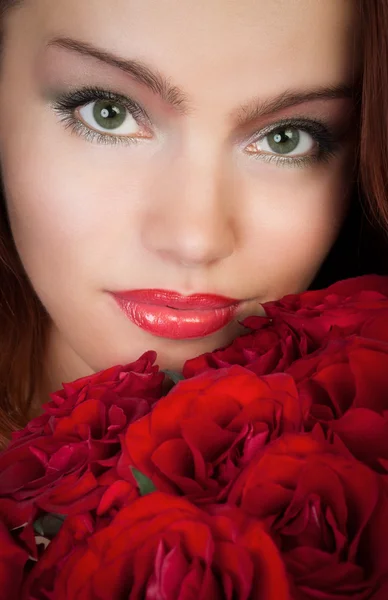 mujer con un ramo de rosas rojas