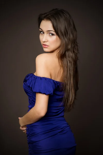 Atraktivní mladá modelka pózuje v modrých šatech. Stock Snímky