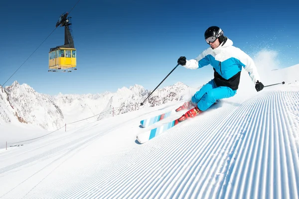 Esquiador en las montañas, preparado pista y día soleado — Foto de Stock