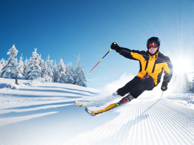 Skier in mountains, prepared piste and sunny day clipart