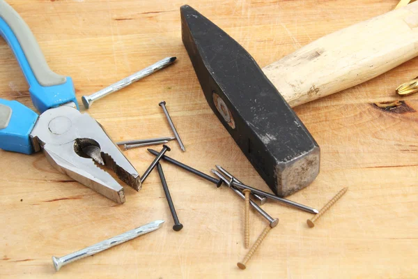 stock image Nails, hammer and pliers on wooden background