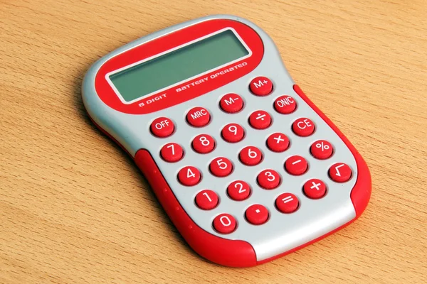 Красный калькулятор на столе — стоковое фото