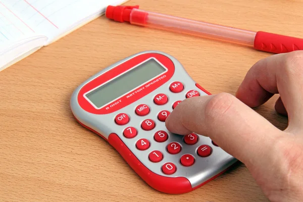 Calculadora roja y una mano — Foto de Stock