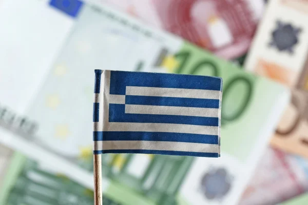 Billetes en euros y bandera griega Imagen de archivo