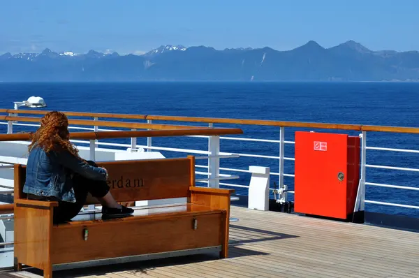 stock image Woman watches mountains on cruise ship