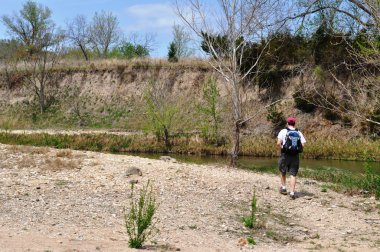 Man hikes along river background clipart