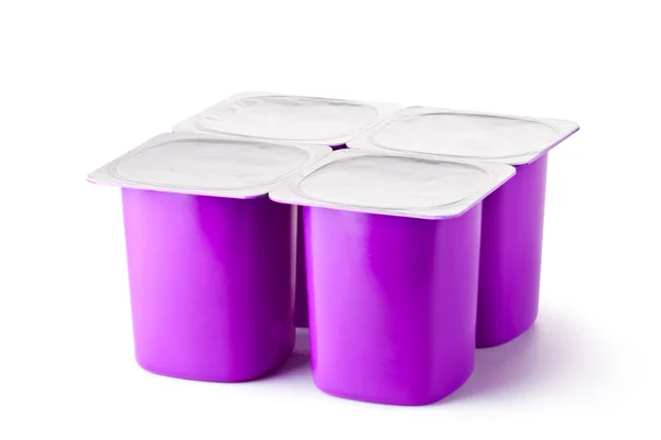 Vier plastic bakjes voor zuivelproducten met folie deksel — Stockfoto