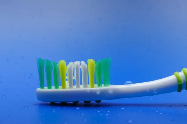 Cepillo de dientes sobre fondo azul — Foto de Stock