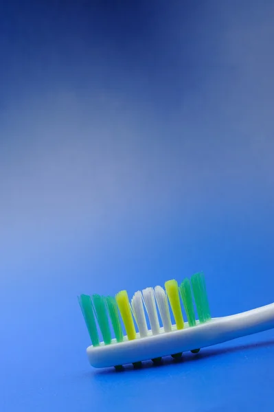 Cepillo de dientes sobre fondo azul — Foto de Stock