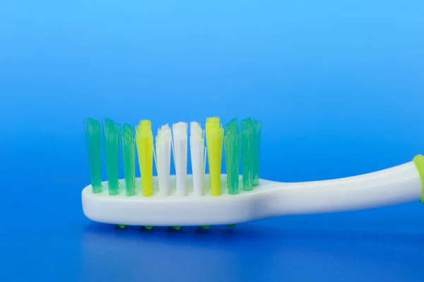 Escova de dentes em um fundo azul — Fotografia de Stock