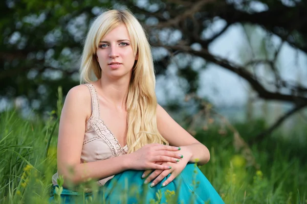 Portret ładna kobieta siedzi w trawie — Zdjęcie stockowe