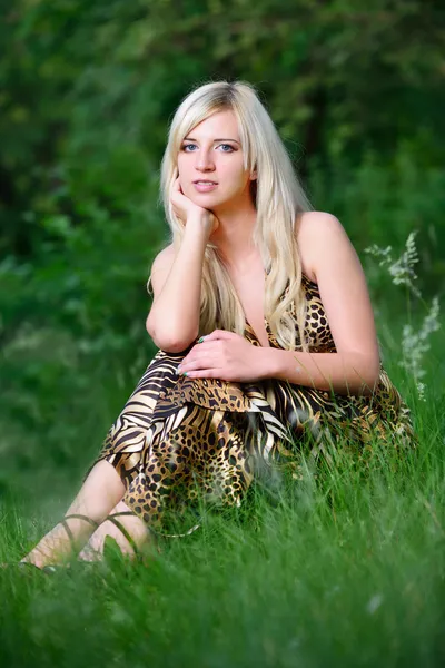 Portrét krásné ženy, sedící v trávě — Stock fotografie