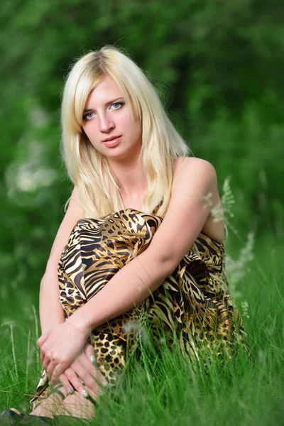 Portrait d'une jolie femme assise dans l'herbe — Photo