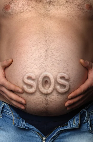 Människans mage med sticker ut inskription Sos — Stockfoto