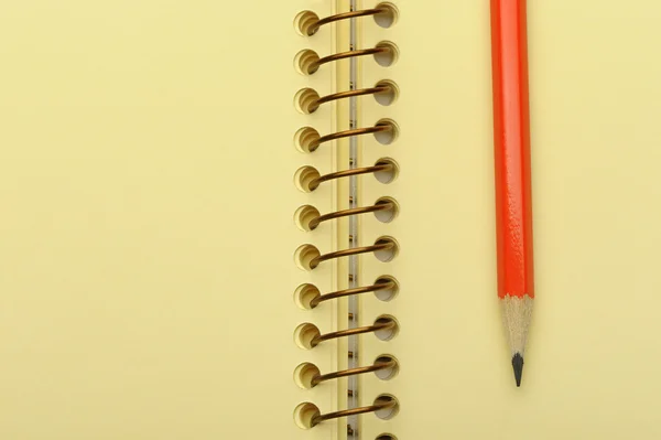 Caderno de papel amarelo e lápis vermelho — Fotografia de Stock