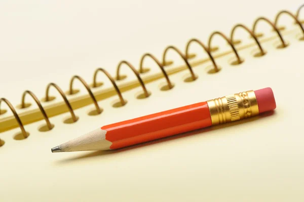 Cuaderno papel amarillo y lápiz rojo —  Fotos de Stock