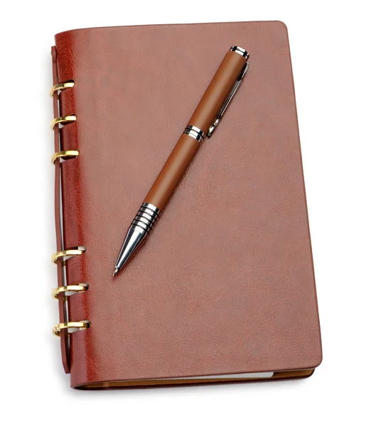 茶色の革のカバーとスタイリッシュなペンでノート ストックフォト
