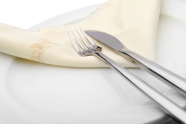Een mes en vork liggen op servetring en een plaat — Stockfoto