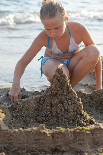 The girl builds sand castle — Stock Photo, Image