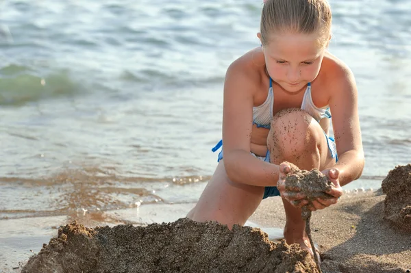 女の子は砂の城を構築します — ストック写真