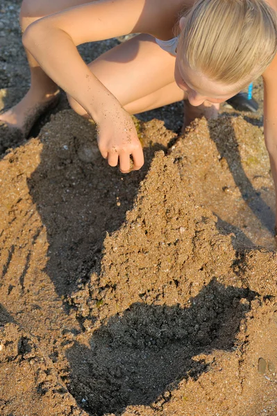 Dívka staví hrad z písku — Stock fotografie