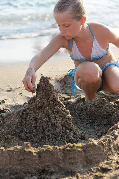 女の子は砂の城を構築します — ストック写真