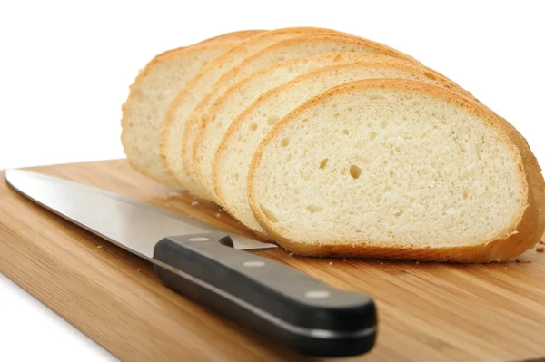 Il pane di taglio su un tagliere con un coltello — Foto Stock