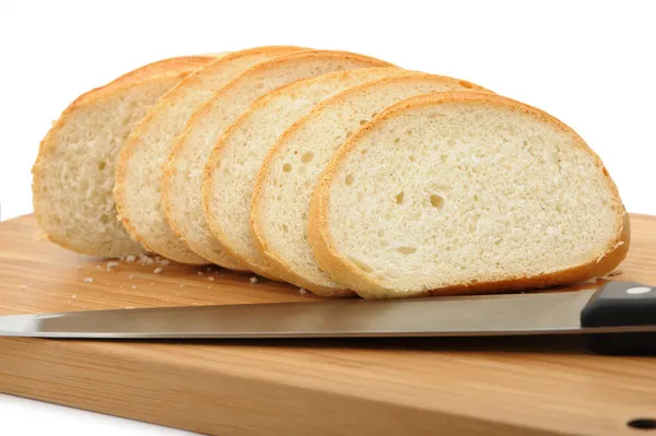 Cięcia chleba na deskę do krojenia nożem — Zdjęcie stockowe