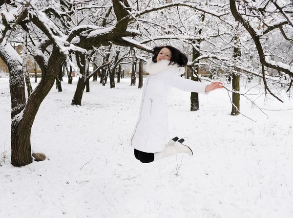 Das Mädchen springt im Winterwald. — Stockfoto