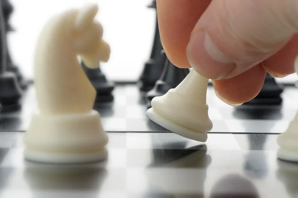 Pawn in hands over a chessboard — Stock Photo, Image