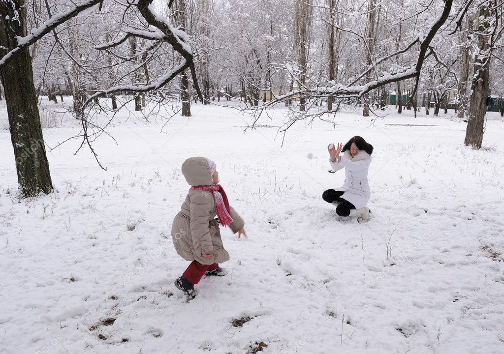 Mum and the daughter play snowballs