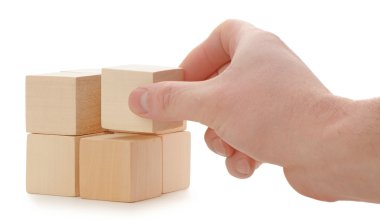 The hand establishes a wooden cube clipart