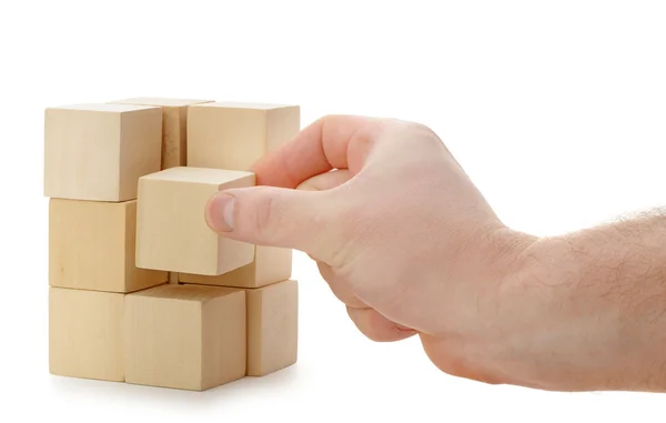 The hand establishes a wooden cube — Stock Photo, Image
