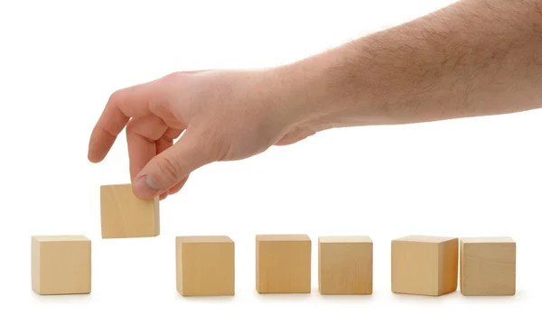The hand establishes a wooden cube in row — Stock Photo, Image