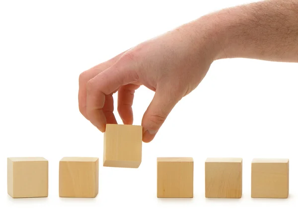 The hand establishes a wooden cube in row — Stock Photo, Image