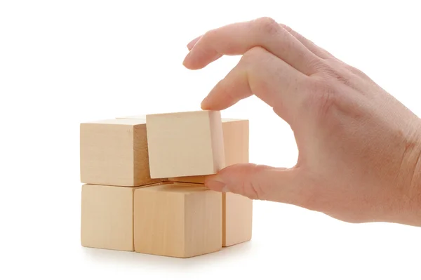 De hand stelt een houten kubus — Stockfoto
