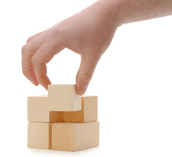 The hand establishes a wooden cube — Stock Photo, Image