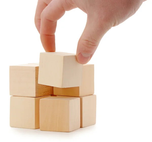 A mão estabelece um cubo de madeira — Fotografia de Stock